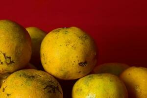 frisch Orange Obst im das rot Hintergrund foto