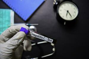 Hepatitis c - - Prüfung mit Blut Probe. oben Aussicht isoliert auf schwarz Hintergrund. Gesundheitswesen medizinisch Konzept foto