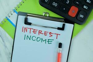 Konzept von Interesse Einkommen schreiben auf ein Papierkram isoliert auf hölzern Tisch. foto