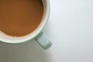 schließen oben heiß Cappuccino Kaffee im ein Blau Tasse isoliert auf ein Weiß Hintergrund foto