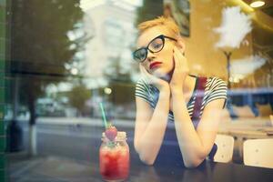 Frau mit Brille Sitzung im ein Restaurant Cocktail Ferien Einsamkeit foto