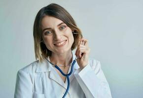 Krankenschwester im ein medizinisch Kleid und ein Stethoskop um ihr Hals Lächeln Porträt foto