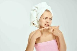 Frau mit nackt Schultern drückt aus Pickel auf das Gesicht Dermatologie Akne foto