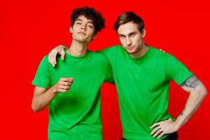 zwei Mann Grün T-Shirts Umarmung Emotionen Freundschaft rot Hintergrund foto