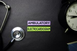 ambulant Elektrokardiogramm Text auf klebrig Anmerkungen. oben Aussicht isoliert auf schwarz Hintergrund. Gesundheitswesen medizinisch Konzept foto
