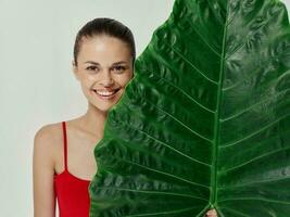 Frau im rot Badeanzug Grün Palme Blatt exotisch Licht Hintergrund foto