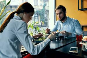 Frau und Geschäft Mann haben Abendessen beim ein Tabelle im ein Cafe köstlich Essen foto