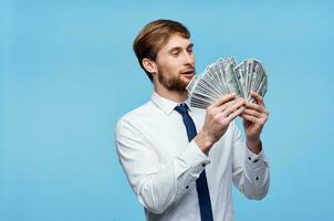 Reich Mann im passen mit Geld im Hände Emotionen Blau Hintergrund foto