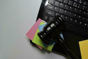 Tastatur Laptop und Hammer isoliert auf Büro Schreibtisch. Gesetz Konzept foto