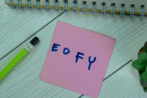 Konzept von eofy schreiben auf klebrig Anmerkungen isoliert auf hölzern Tisch. foto