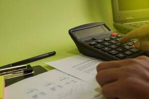 Mann Berechnung Budget Kosten und Analyse finanziell. selektiv Fokus auf Taschenrechner. Geschäft und Finanzen Konzept von Büro Schreibtisch foto