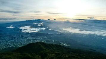 Panorama von fließend Nebel Wellen auf Berg tropisch Regenwald, Bild Über das Wolken tolle Natur Hintergrund mit Wolken und Berg Spitzen im purbalingga. zentral Java, Indonesien. Dezember 13, 2022 foto