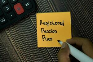 Eingetragen die Pension planen schreiben auf klebrig Anmerkungen isoliert auf Büro Schreibtisch. foto
