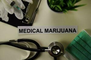 medizinisch Marihuana mit Inspiration und Gesundheitswesen medizinisch Konzept auf Schreibtisch Hintergrund foto