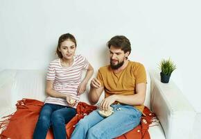 Mann Essen Popcorn und ziemlich Frau im ein hell Zimmer Familie freunde Kommunikation foto