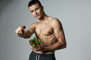 sportlich Mann muskulös Torso Teller Salat gesund Essen isoliert Hintergrund foto