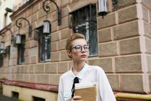 ziemlich Frau auf das Straße in der Nähe von das Gebäude sich ausruhen Bildung foto