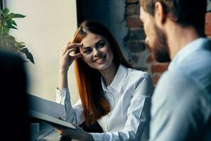 Geschäft Mann und Frau Sitzung beim das Tabelle Arbeit Kommunikation Büro foto