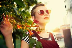 kurz behaart Frau tragen Sonnenbrille draußen Blumen Dekoration foto