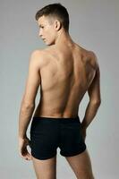 Mann mit gepumpt oben Arm Muskeln nackt zurück grau Hintergrund Modell- foto
