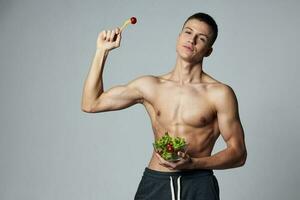 sportlich Mann mit muskulös Körper Teller Salat Diät Essen isoliert Hintergrund foto