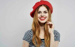 heiter Frau gestreift T-Shirt mit rot Hut Lächeln Charme Modell- foto