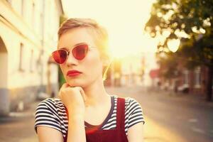 ziemlich Frau tragen Sonnenbrille draußen posieren Sommer- foto