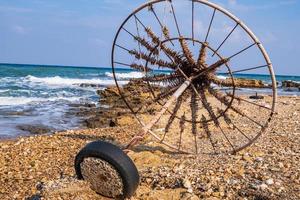 verlassener Sonnenschirm an einem felsigen Strand gegen das Meer foto