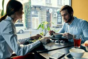 Frau und Geschäft Mann haben Abendessen beim ein Tabelle im ein Cafe köstlich Essen foto
