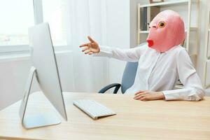 wütend Geschäftsfrau im Rosa Fisch Maske schreiend zu Desktop tobt nach Computer Software Absturz Error beim Arbeitsplatz im modern Büro. verrückt Direktor Arbeit online im finanziell Konzern. Kopieren Raum foto