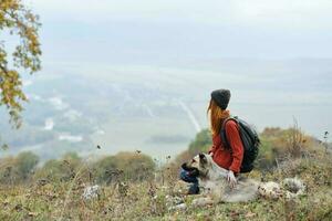 Frau Wanderer mit ein Rucksack im Natur mit ein Hund foto