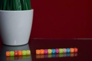 Werdegang Entwicklung Text beim bunt hölzern Block auf rot Hintergrund. Schreibtisch Büro und Bildung Konzept foto