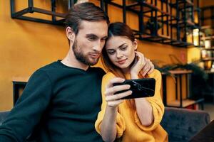 ein Frau Fotografien Sie selber und ein jung Mann beim ein Tabelle im ein Cafe Restaurant freunde Paar im Liebe foto