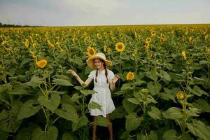 schön Süss Mädchen im ein Hut auf ein Feld von Sonnenblumen Landschaft foto