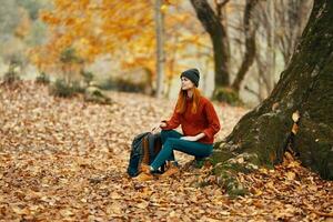 Frau im das Park Landschaft fallen Blätter Reise Natur Herbst Modell- Rucksack foto