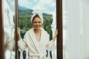 Frau im ein Weiß Kleid auf das Balkon bisschen auf Grün Natur Lebensstil foto