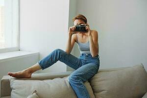 Frau Fotograf Schießen im Studio auf alt Film Kamera beim Zuhause auf Couch Porträt, Weiß Hintergrund, kostenlos Kopieren Raum, freiberuflich Fotograf foto