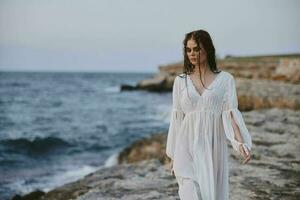 attraktiv Frau im Weiß Kleid beim das Meer Strand Natur unverändert foto