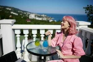 glamourös Frau genießen ein bunt Cocktail Hotel Terrasse glücklich weiblich entspannend foto