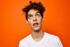 heiter Kerl im ein Weiß T-Shirt Emotion Nahansicht Orange Hintergrund foto