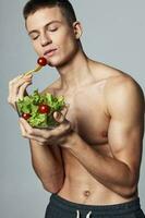 Mann mit nackt Schultern Teller Salat gesund Ernährung Bodybuilder Energie foto