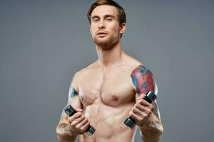 Kerl mit ein nackt Torso gepumpt oben Arm Muskeln Hanteln Fitness Bodybuilding Sport foto