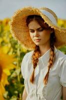 Frau mit zwei Zöpfe im ein Stroh Hut im ein Weiß Kleid ein Feld von Sonnenblumen Landwirtschaft unverändert foto