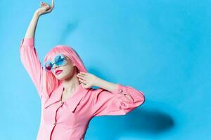 Porträt von ein Frau im Blau Brille trägt ein Rosa Perücke Studio Modell- unverändert foto