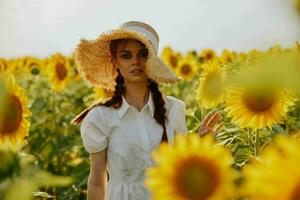 Frau Porträt im ein Hut auf ein Feld von Sonnenblumen Sommer- Zeit foto