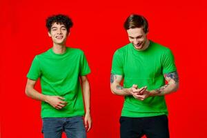zwei heiter freunde im Grün T-Shirts Freude von Kommunikation foto