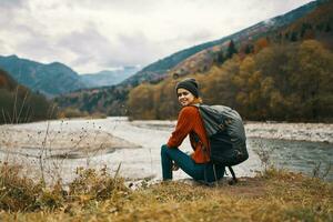 Frau mit Rucksack durch das Fluss Berg Landschaft Herbst trocken Gras Modell- foto