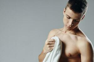 sportlich Mann abgeschnitten Aussicht nackt Schultern mit Handtuch im Hände trainieren foto