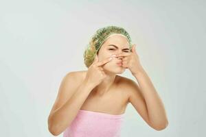 Frau drückt Pickel auf ihr Gesicht Dermatologie Haut Probleme foto
