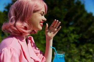 attraktiv Frau im Rosa Kleid draußen mit Cocktail Trinken Alkohol foto